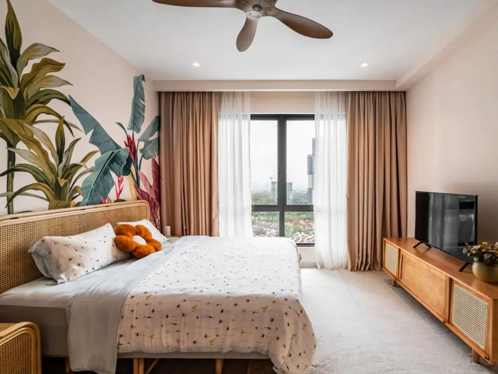 appartement moderne chic colore chambre à coucher tendance papier peint panoramique fresque tropical couleur rideau et voilage baie vitrée meuble en cannage