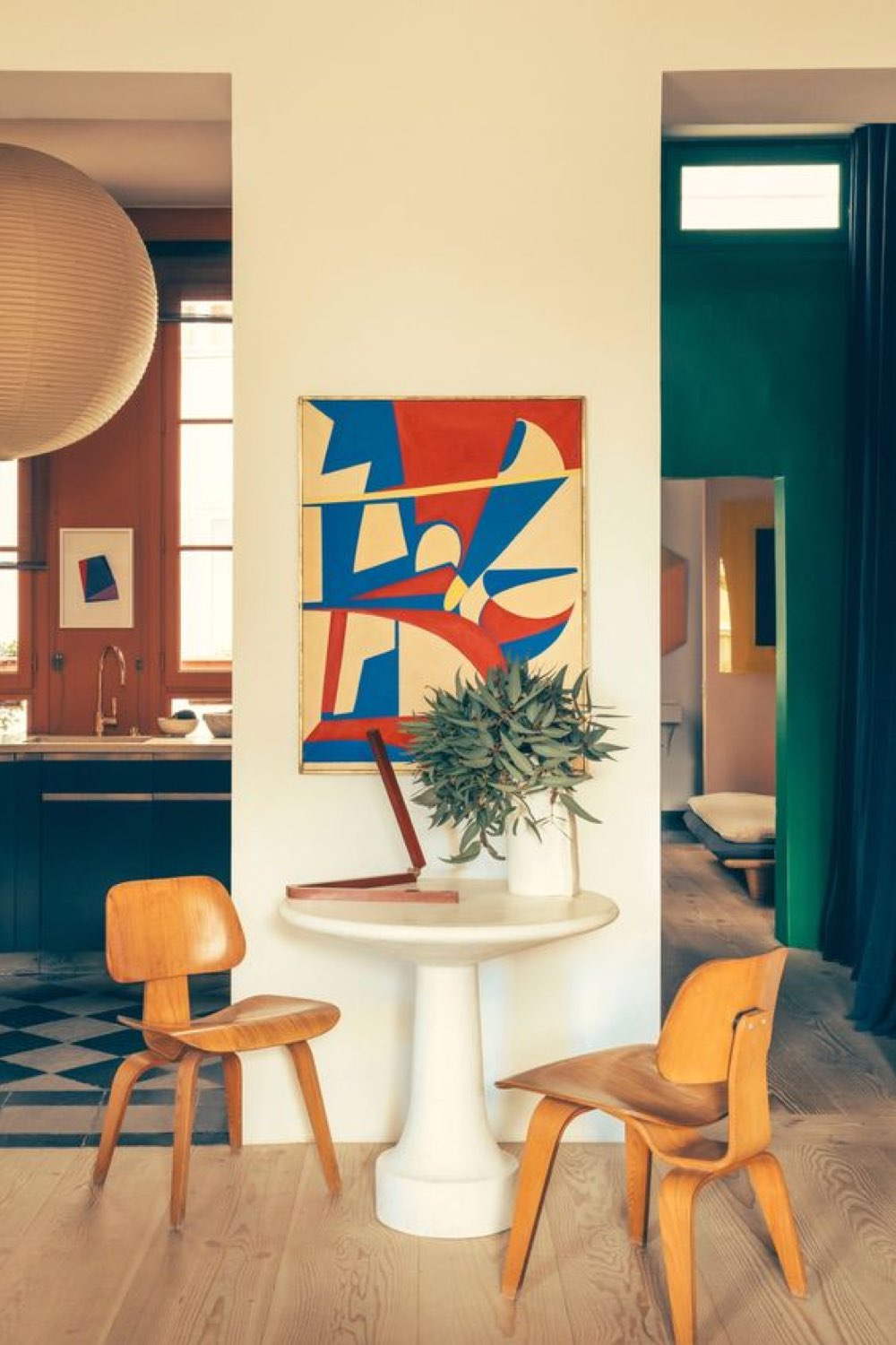 caracteristique decoration modern design pan de mur tableau abstrait coloré rouge et bleu chaise en bois vintage table ronde coin café appartement