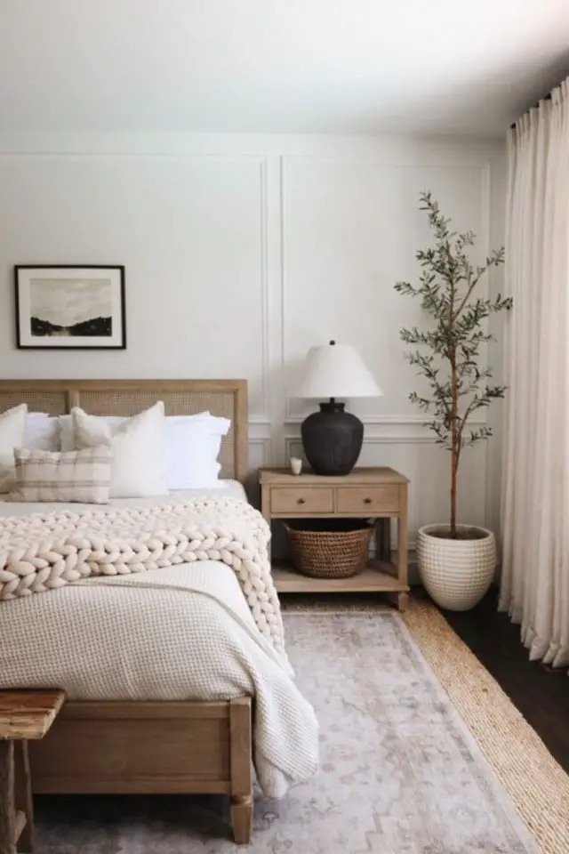 chambre a coucher cocooning moderne espace lumineux clair écru blanc cosy plaid en laine tapis beige table de chevet en bois