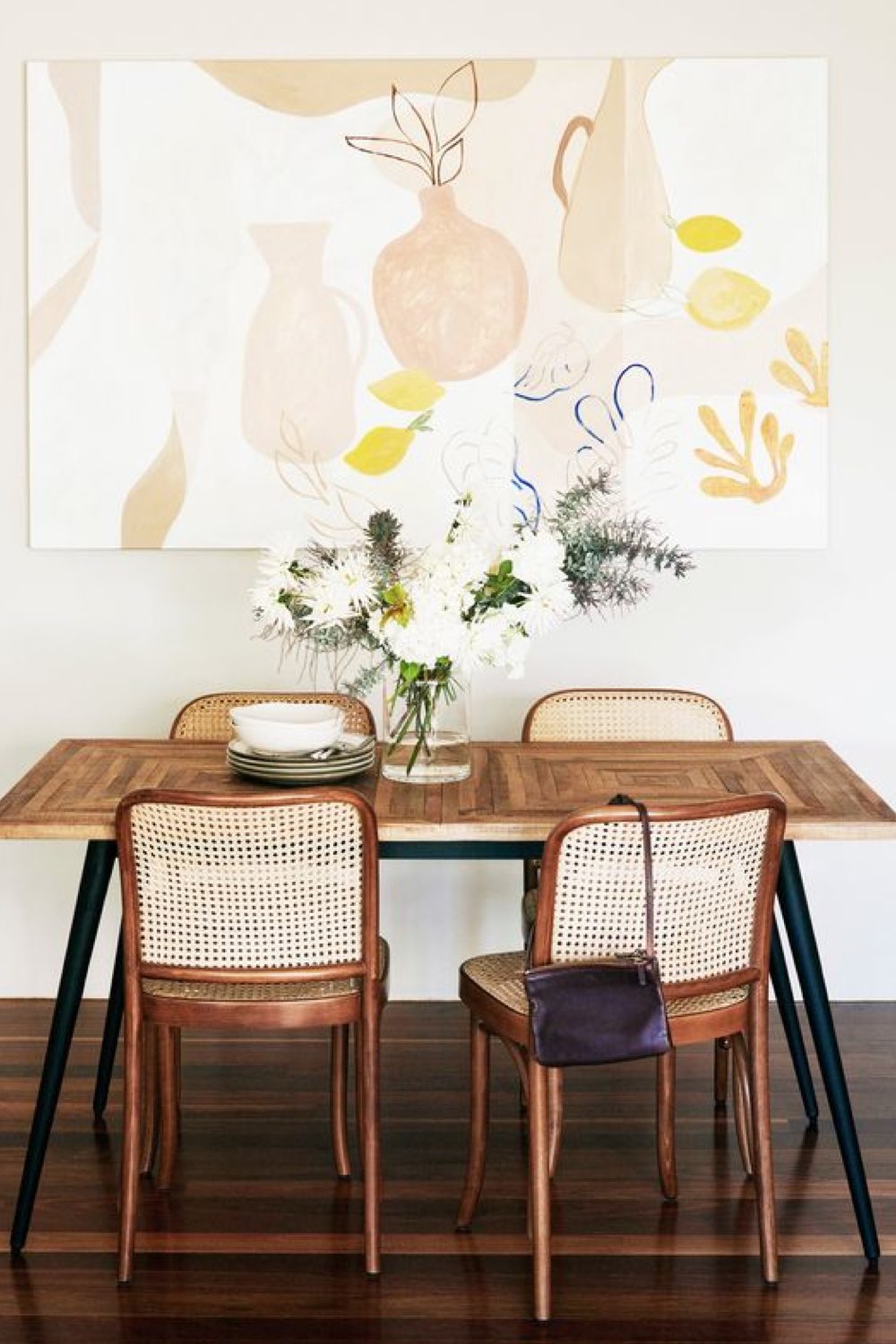 comment reussir deco salle a manger petite table pour 4 personnes en bois en bois et piètement métal chaises vintage sombre avec cannage grand tableau moderne effet aquarelle pastel