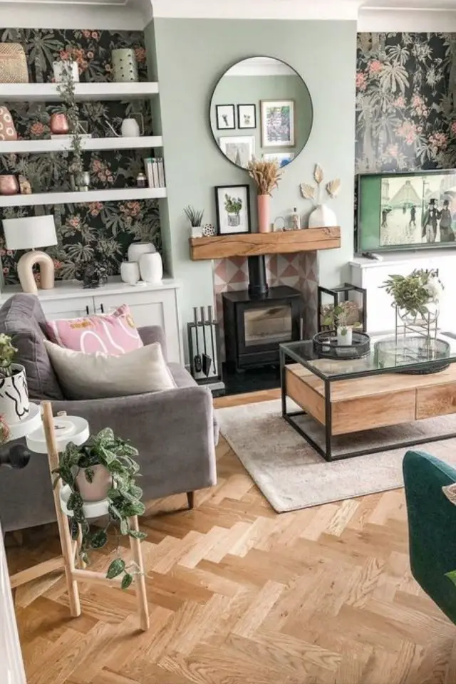 decoration salon photo moderne 2024 cheminée bois poêle couleur vert clair parquet en chevrons fauteuil gris cosy