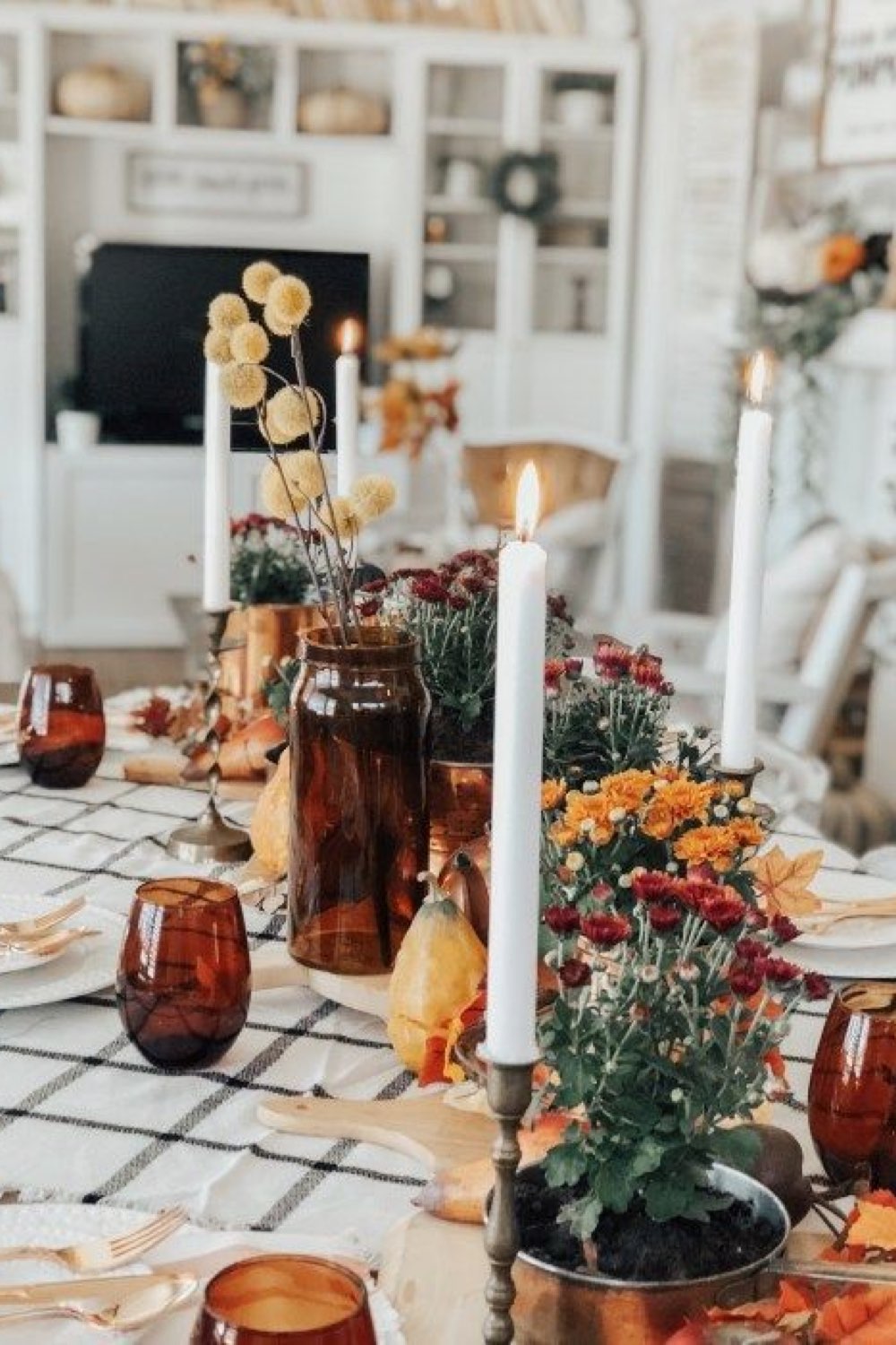 decoration table automne facile a faire nappe écrue et noir à carreaux bougies blanche petits bouquets de fleurs orange verre fumé marron
