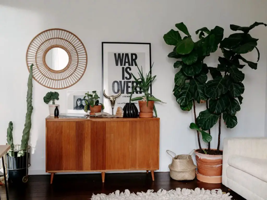 maison moderne familiale boheme retro espace travail salon meuble en bois buffet vintage miroir rond en rotin grande plante verte