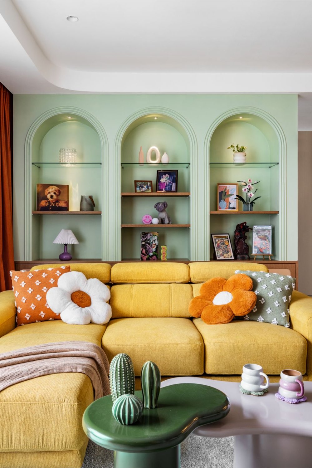 visite appartement moderne chic colore rangement salon séjour niche cintrée en forme d'arche avec étagère tablette en verre grand canapé jaune