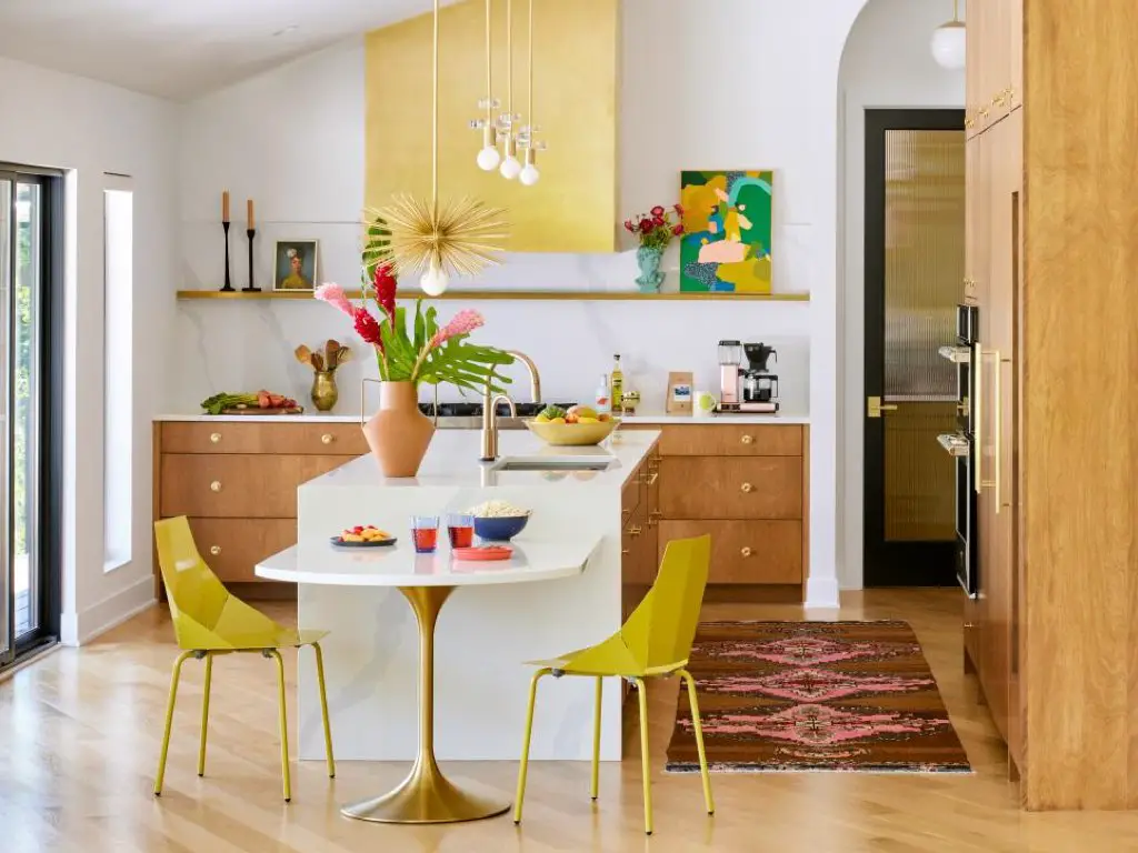 visite maison renovation mid century modern cuisine avec îlot central blanc jaune pastel hotte chaise meuble bas en bois foncé