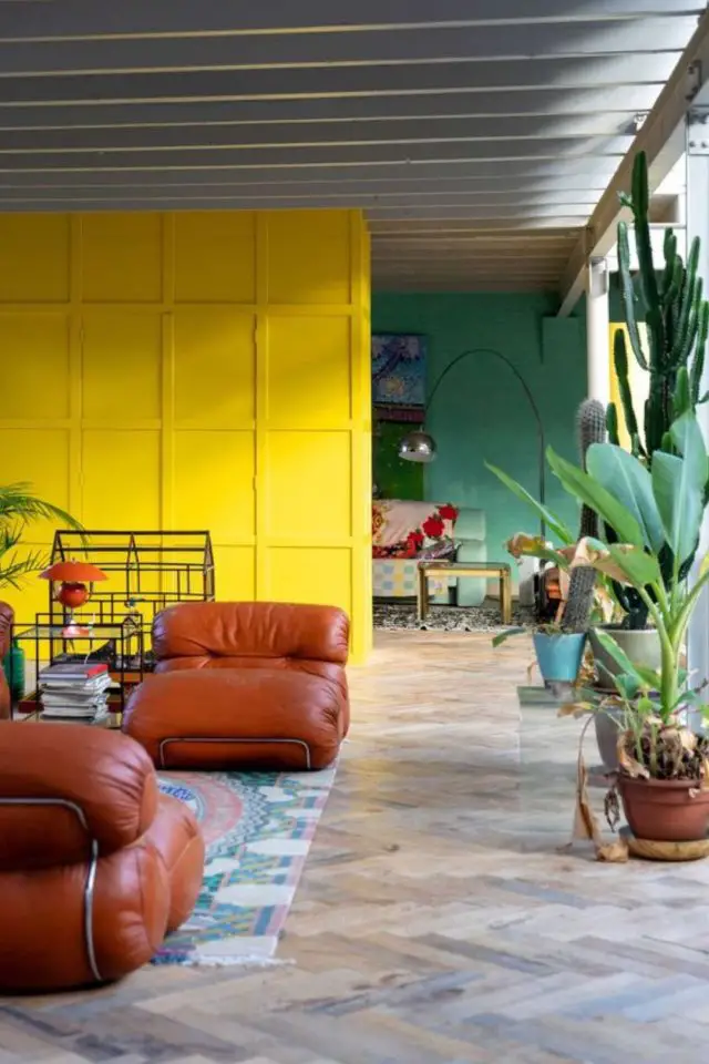 creer touche de couleur deco exemple salon séjour grande pièce à vivre mur jaune vert  plantes tapis coloré fauteuil design en cuir