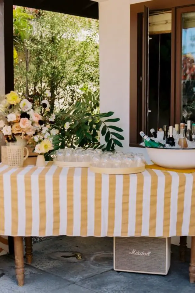 deco buffet apero dinatoire a la maison jardin anniversaire table nappe verre et bouteille dans glaçons fleurs