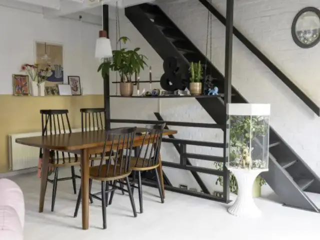 renovation atelier en loft eclectique coin salle à manger sous mezzanine près escaliers noirs mobilier en bois sombre