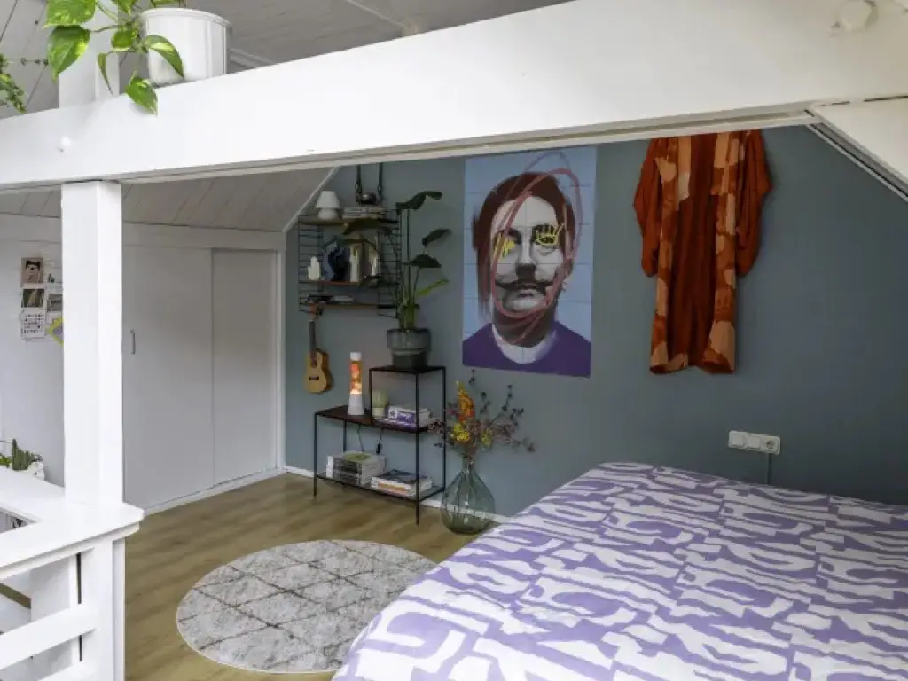renovation atelier en loft eclectique mur accent peint en bleu chambre adulte en mezzanine tableau Dali coloré