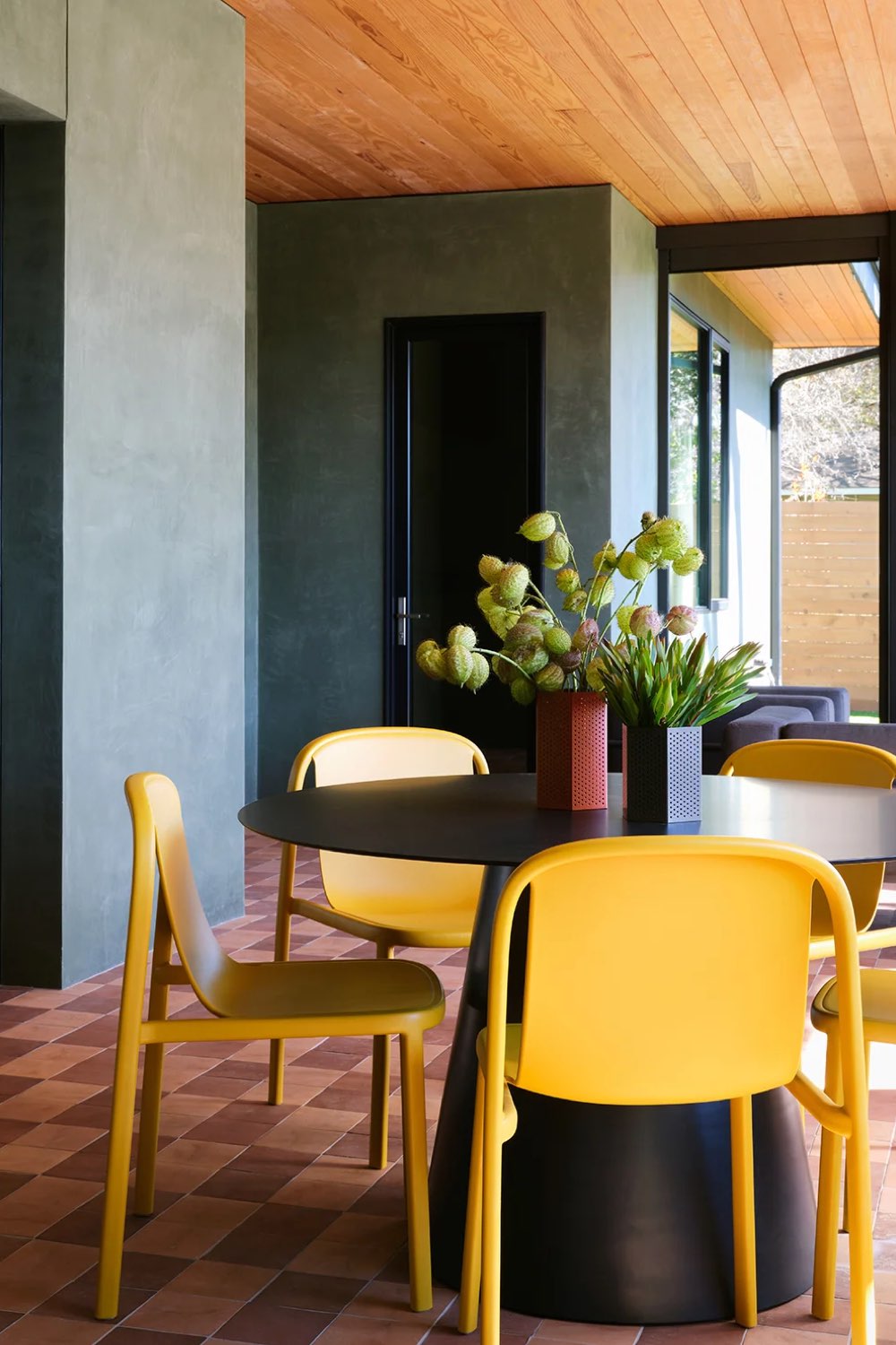 visite interieur maison decor moderne et classique chic coin salle à manger table noire ronde moderne chaise colorée jaune mur chic anthracite et revêtement original plafond