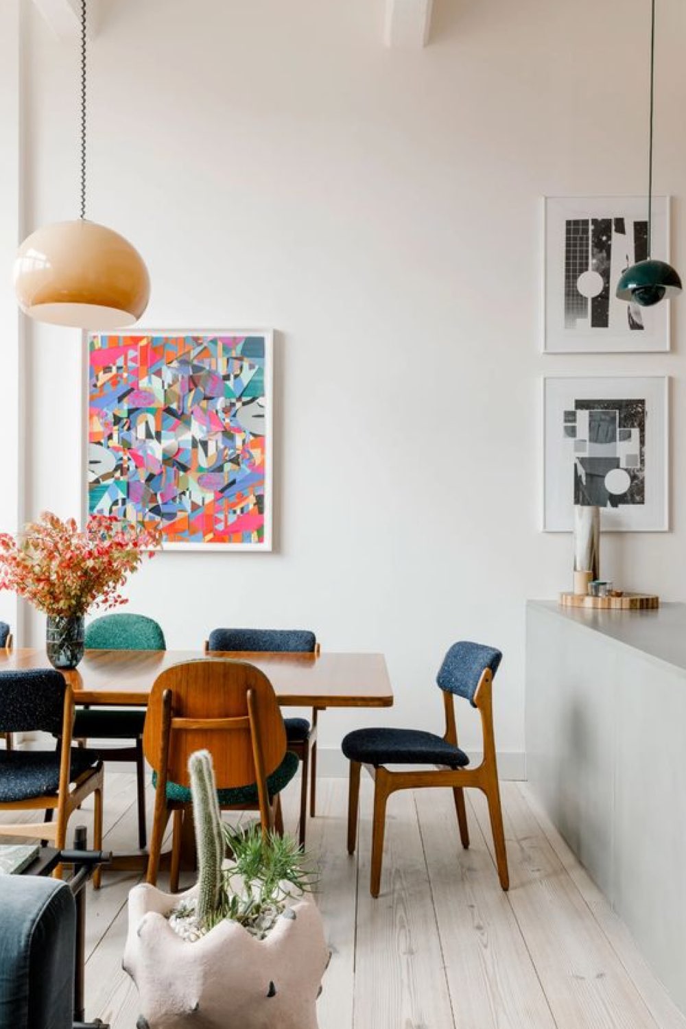 salle a manger deco style vintage moderne grand espace blanc chaises rétro colorées et bois suspension boule tableau multicolore