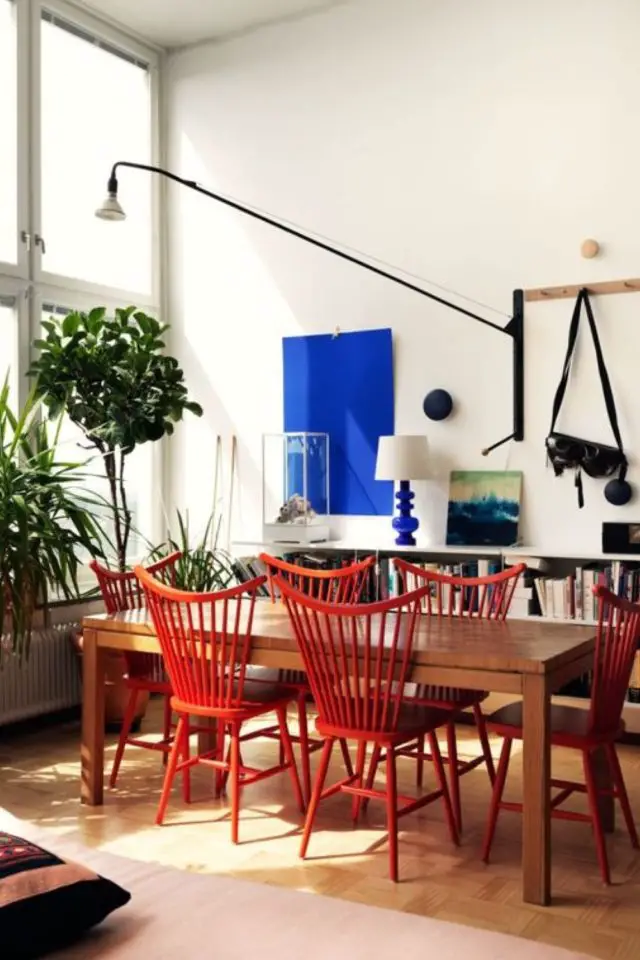salle a manger deco style vintage moderne chaises design scandinave rouge table en bois grand luminaire noir tableau monochrome bleu électrique