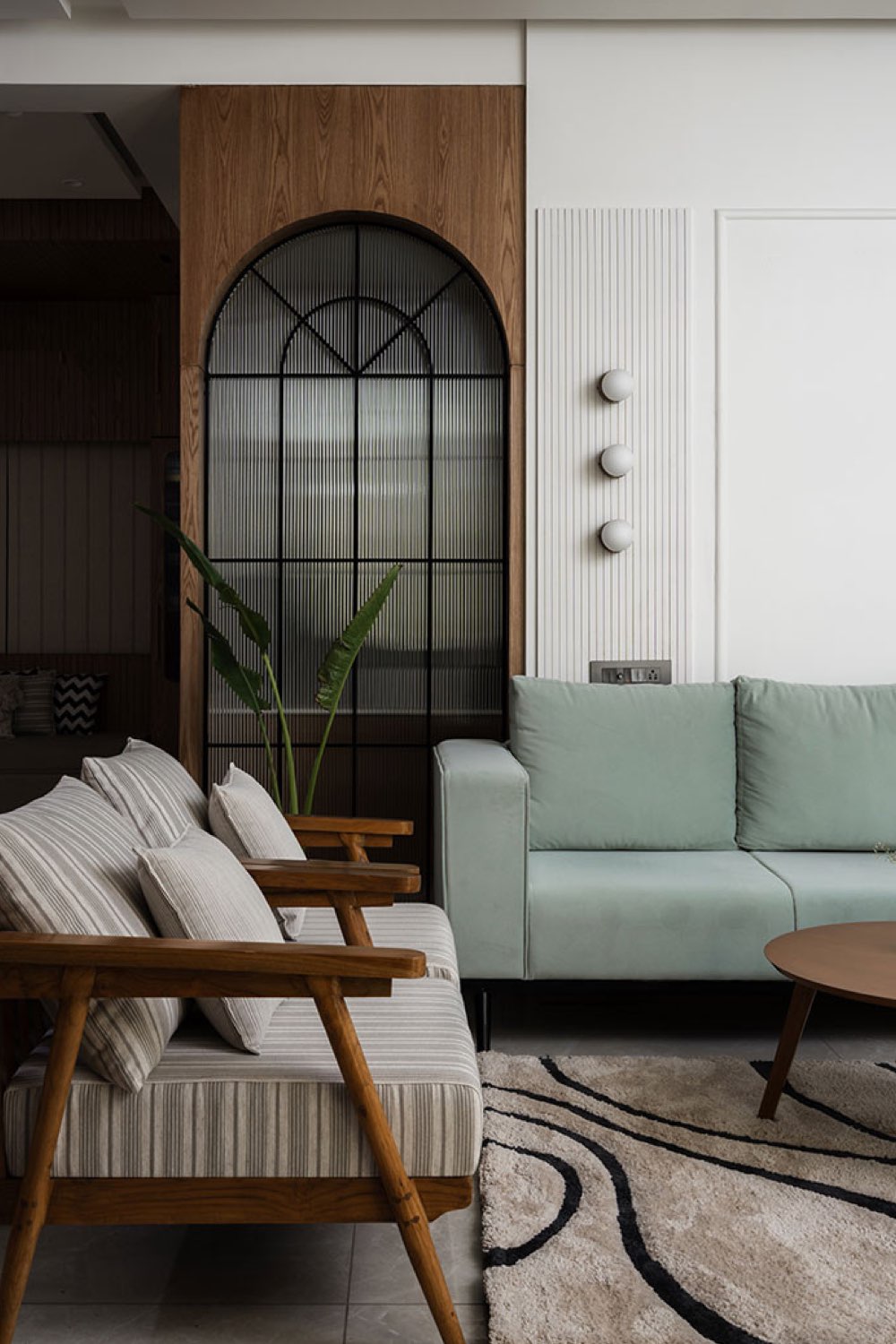 appartement lumineux moderne decor nature salon contemporain canapé vert gris fauteuil en bois avec coussin neutre moulure murale en ton sur ton