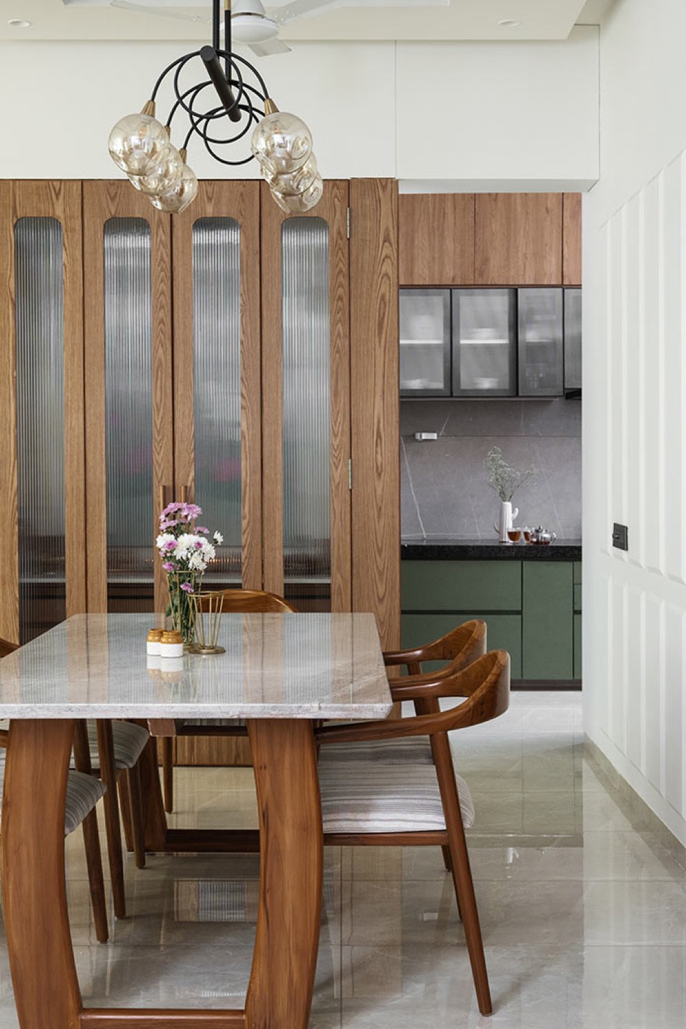 appartement lumineux moderne decor nature salle à manger moderne et chic meuble en bois sur-mesure table plateau en marbre cuisine verte meuble mural noir et verre 