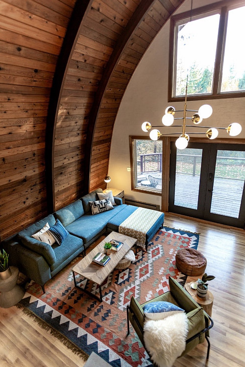 chalet en bois scandinave et cosy salon séjour grand canapé d'angle familial tapis coloré ethnique