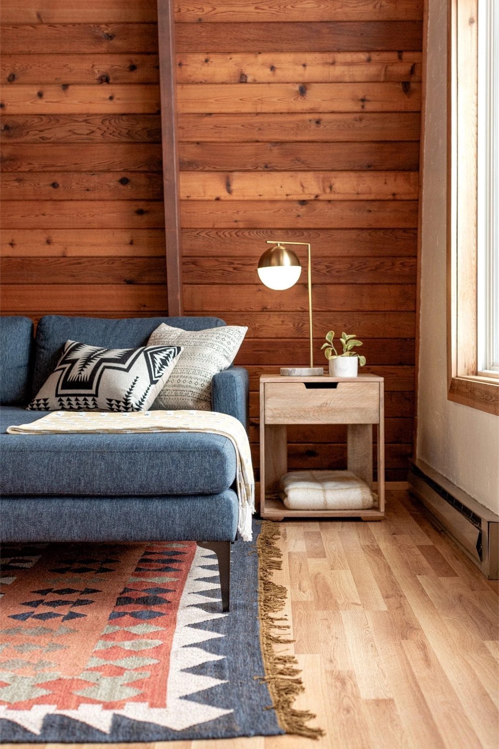exemple chalet esprit scandinave moderne mur en bois lambris naturel cosy et chaleureux salon petit bout de canapé avec lampe à poser style contemporain