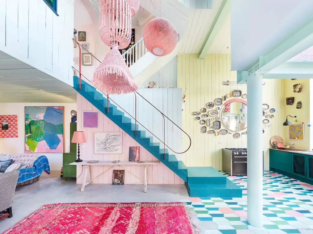 maison couleur pastel douce eclectique cuisine ouverte décloisonnée haut plafond jaune escalier bleu et rose