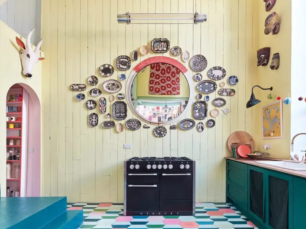 maison couleur pastel douce eclectique déco cuisine originale mur miroir dessus piano de cuisson meuble bas vert bleu canard