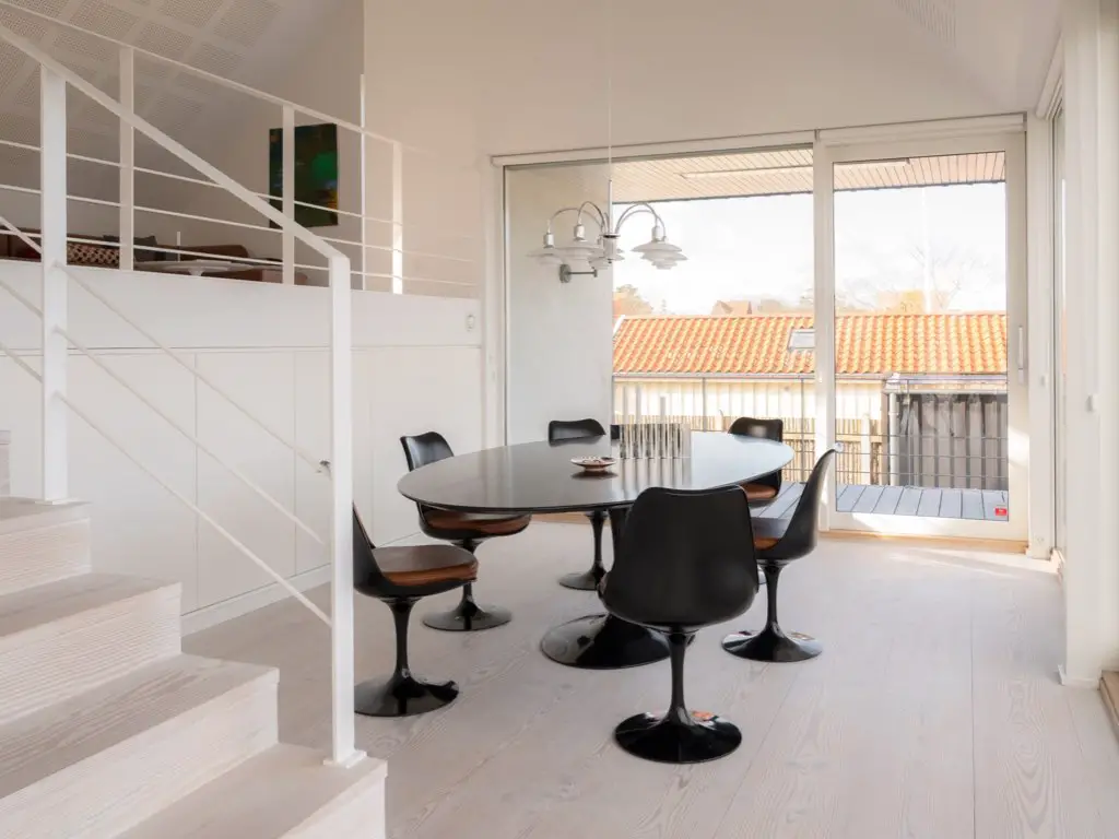 visite maison cotiere ultramoderne et epuree salle à manger minimaliste table tulipe noire suspension design Louis Poulsen