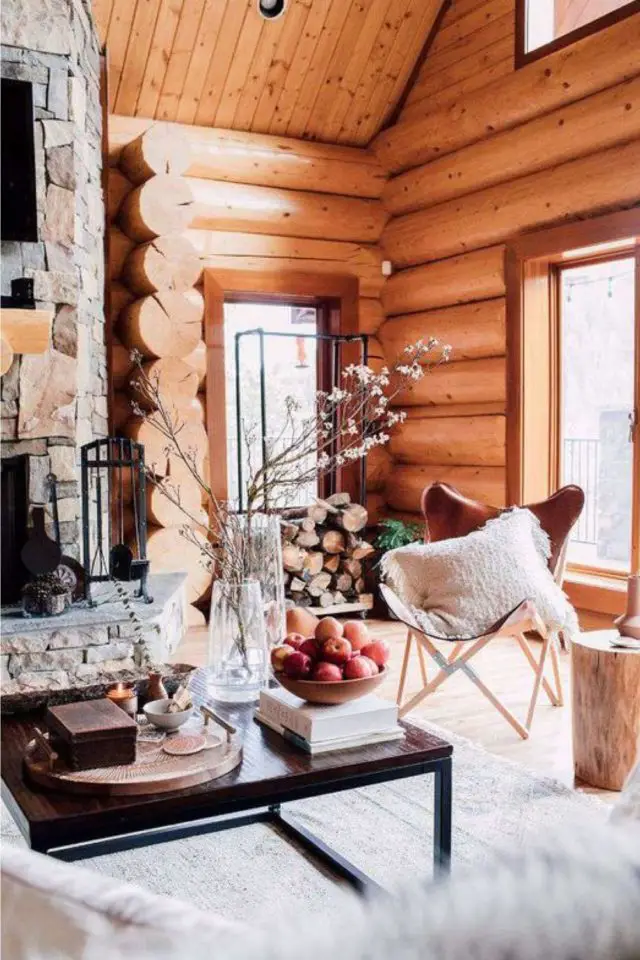 deco style chalet caracteristiques rondin de bois cheminée salon lumineux fauteuil papillon en cuir