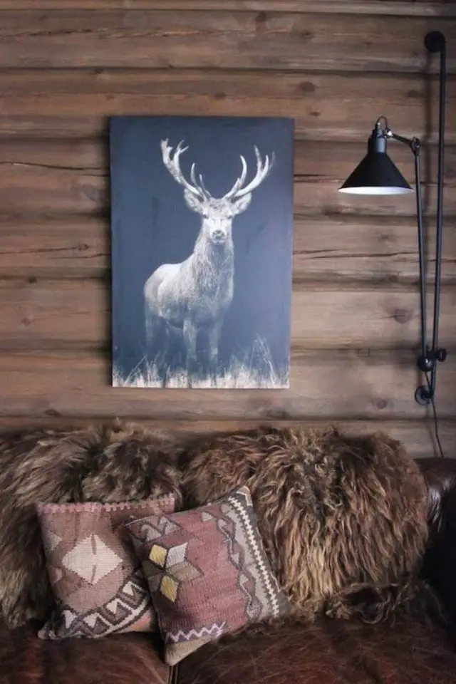 deco style chalet caracteristiques salon séjour lambris mural en bois canapé fourrure affiche animalière