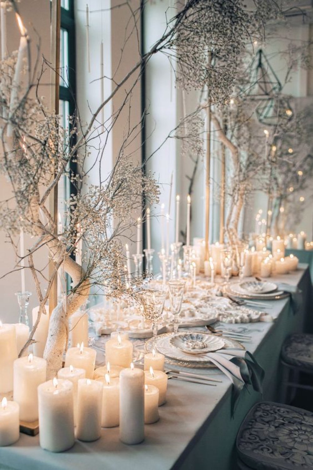 idee decoration mariage hiver décor grande table invité salle de réception nappe grise branche d'arbre blanche bougie élégance