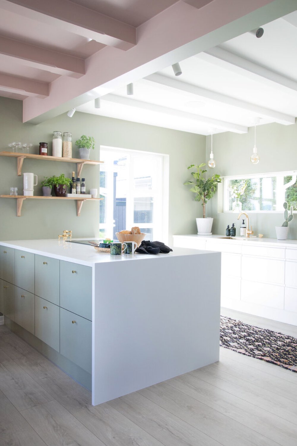 interieur deco peinture pastel cuisine ouverte avec îlot blanc et bleu mur vert sauge plafond rose espace lumineux