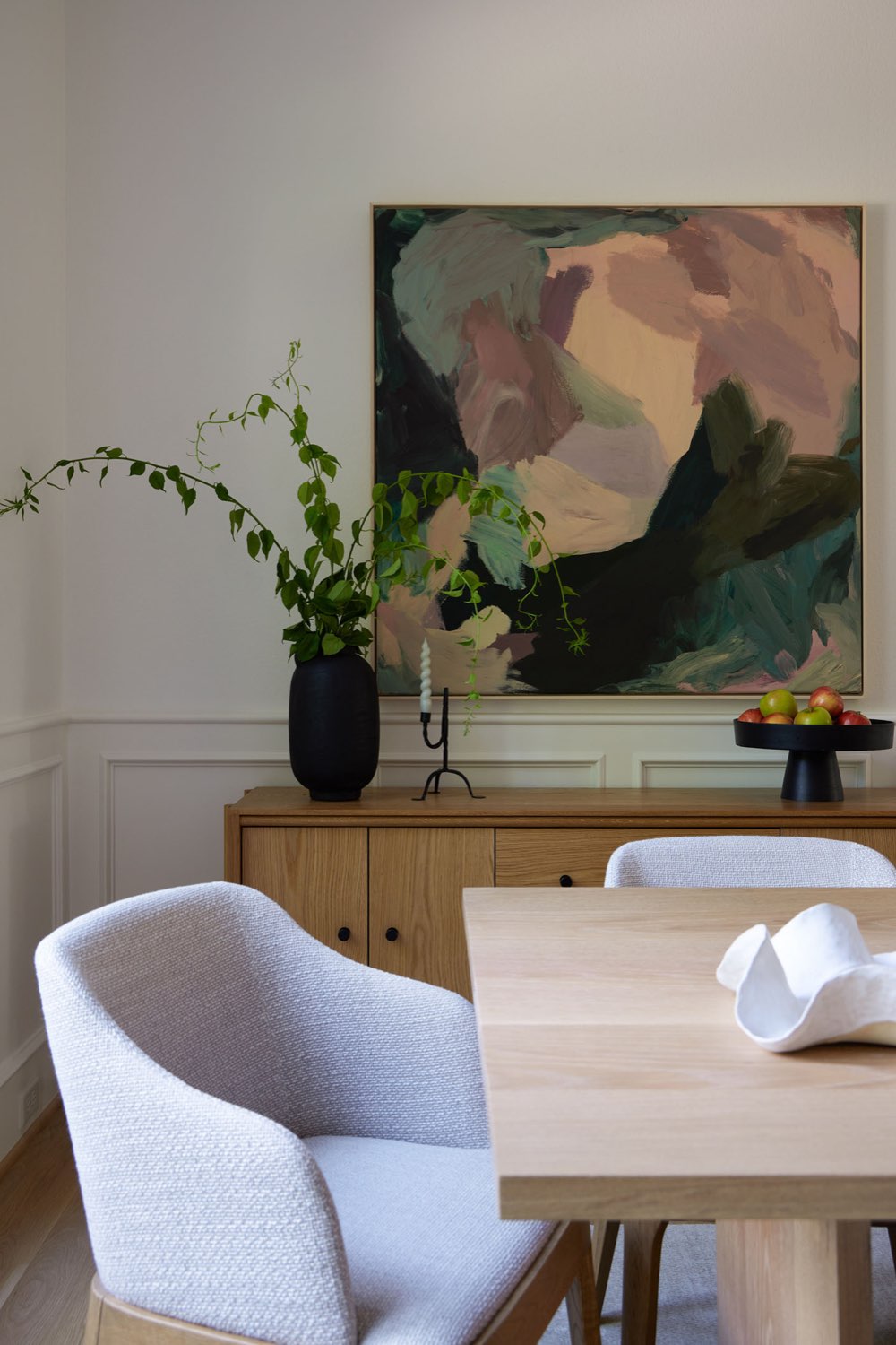 maison classique claire decor equilibre détail decoration salle à manger fauteuil gris tissu et bois table familiale enfilade tableau abstrait