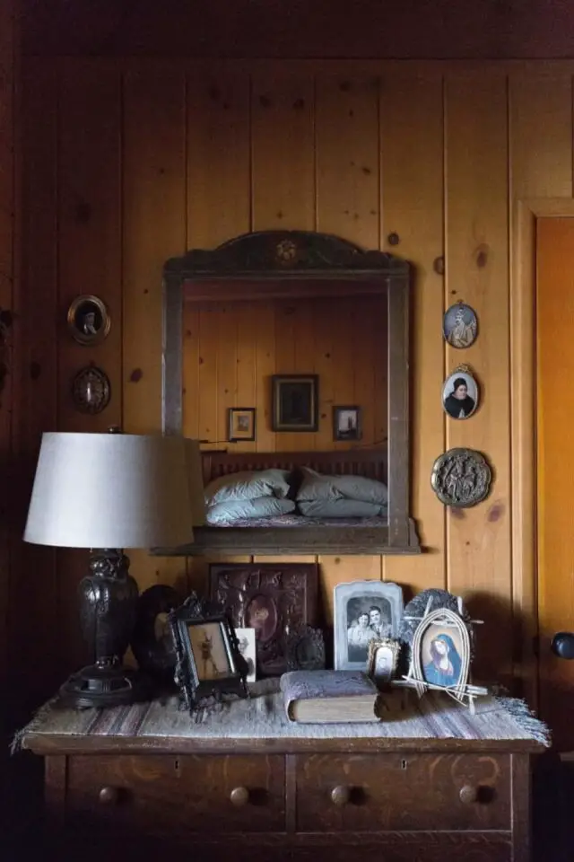 maison en bois deco ancienne eclectique décor chambre à coucher rustique dessus de commode miroir ancien lampe à poser cadres 
