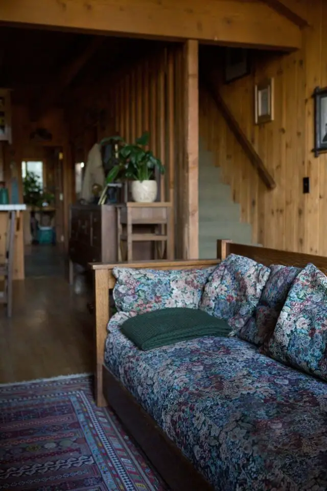 maison en bois deco ancienne eclectique salon séjour canapé en bois housse motif floral cosy