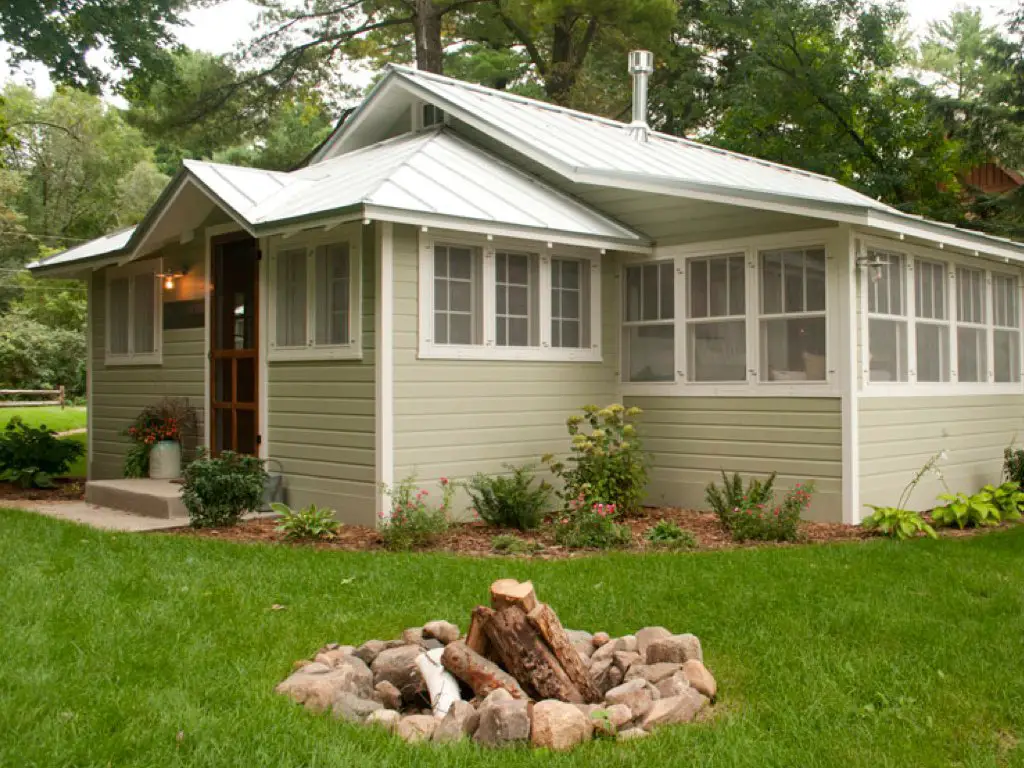 renovation chalet bord de lac bardage bois peint en vert nature