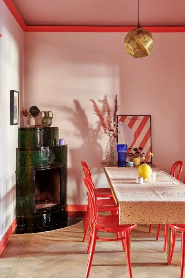 association couleur rose rouge decoration salle à manger peinture originale mur rose boiseries rouges chaises affiche rayée encadrée