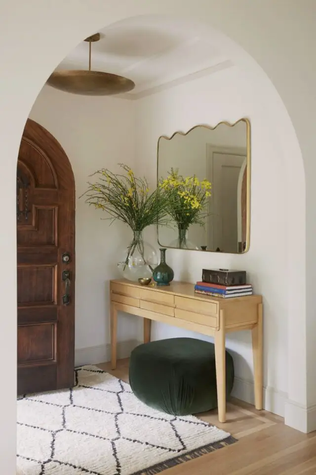 decor interieur relaxant naturel moderne entrée console en bois contre un mur miroir original encadrement laiton pouf en velours vert