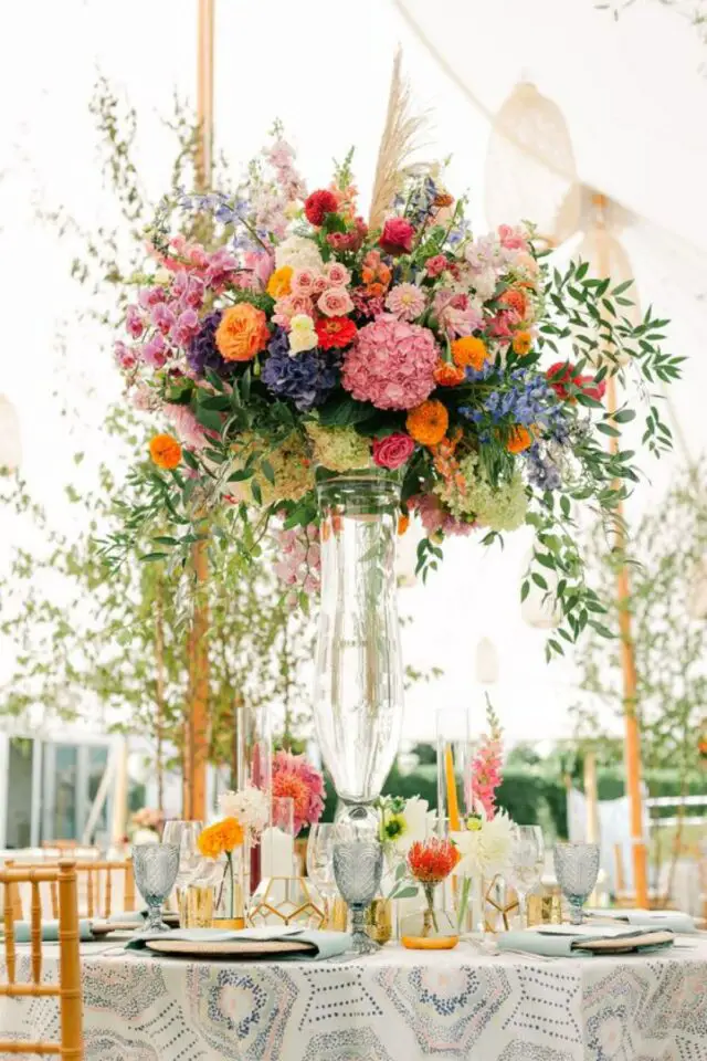 décoration de mariage au printemps centre de table en hauteur grand vase transparent bouquet rond fleurs multicolores