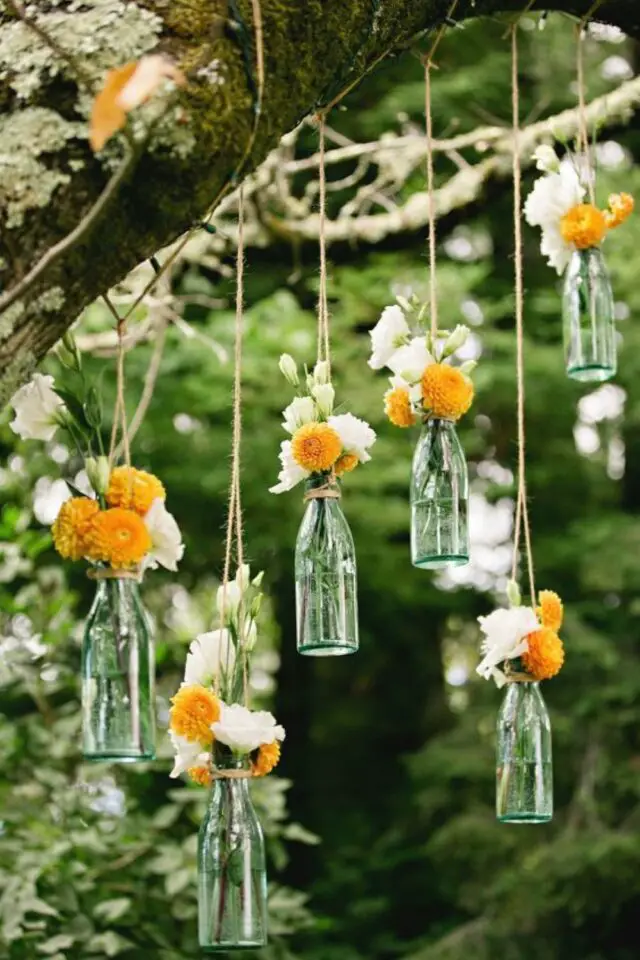 décoration de mariage au printemps déco extérieure parc bouquet de fleurs suspendu à un arbre ficelle bouteille en verre récup 