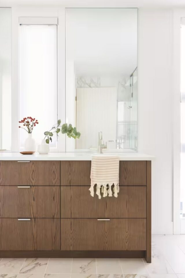 intérieur haut de gamme intemporel salle de bain grand miroir rectangulaire au dessus du meuble vasque en bois espace lumineux