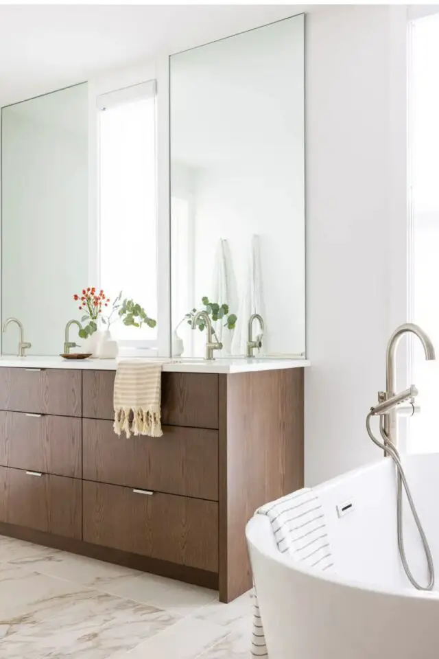 intérieur haut de gamme intemporel salle de bain grand miroir rectangulaire petite fenêtre au dessus du plan vasque meuble en bois