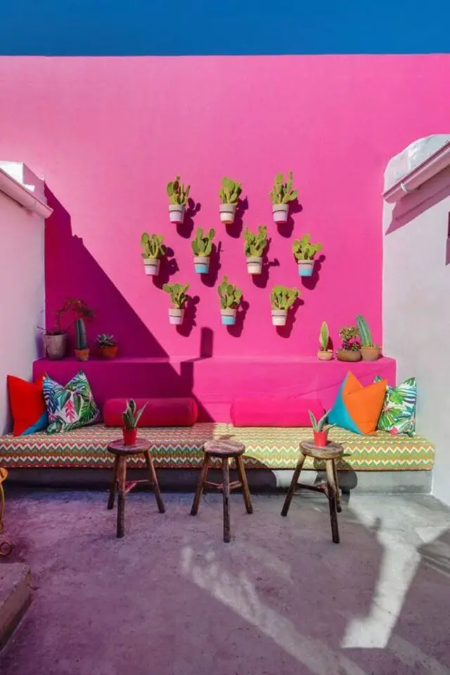 amenagement terrasse pot de fleurs suspendu au mur décor minimaliste et coloré dessus banquette en béton petit cactus original 