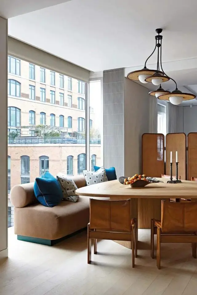 appartement design mid century francais salle à manger séparée avec un paravent en cannage table forme organique en bois chaise fauteuil vintage