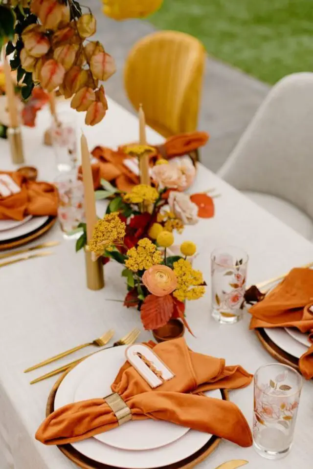 decoration mariage theme groovy table déco simple fond blanc accessoires jaune orange serviette en tissu bougies petit bouquet coloré