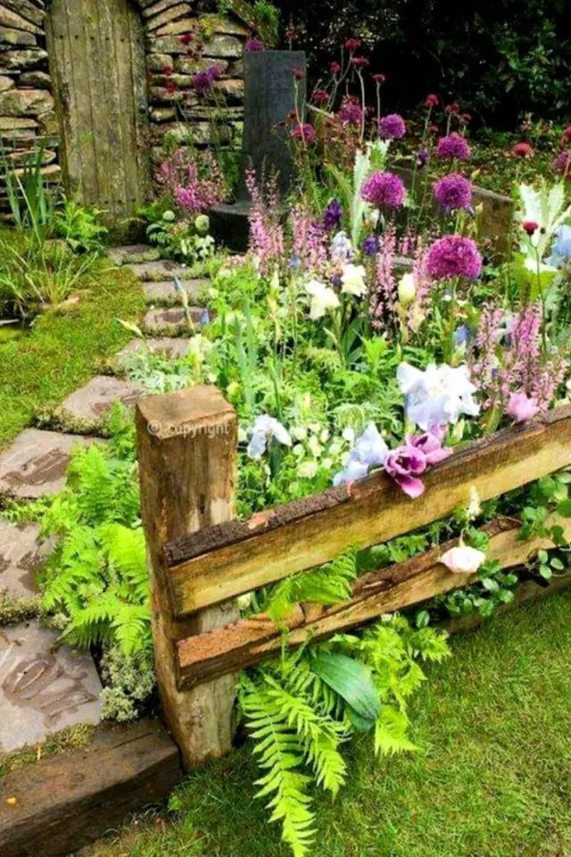 idée décoration jardin rustique campagne clôture en bois massif de fleur et plantes fougères allée en béton simple et chic