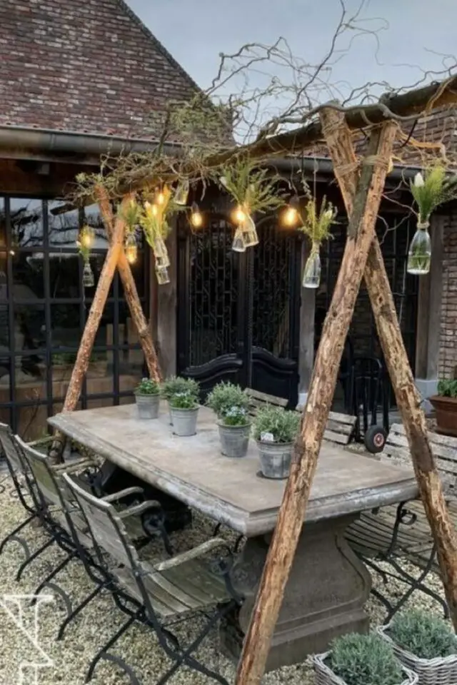 jardin rustique de grand-mère table en bois et béton avec triangle pour suspendre de la lumière chaises en bois et métal 