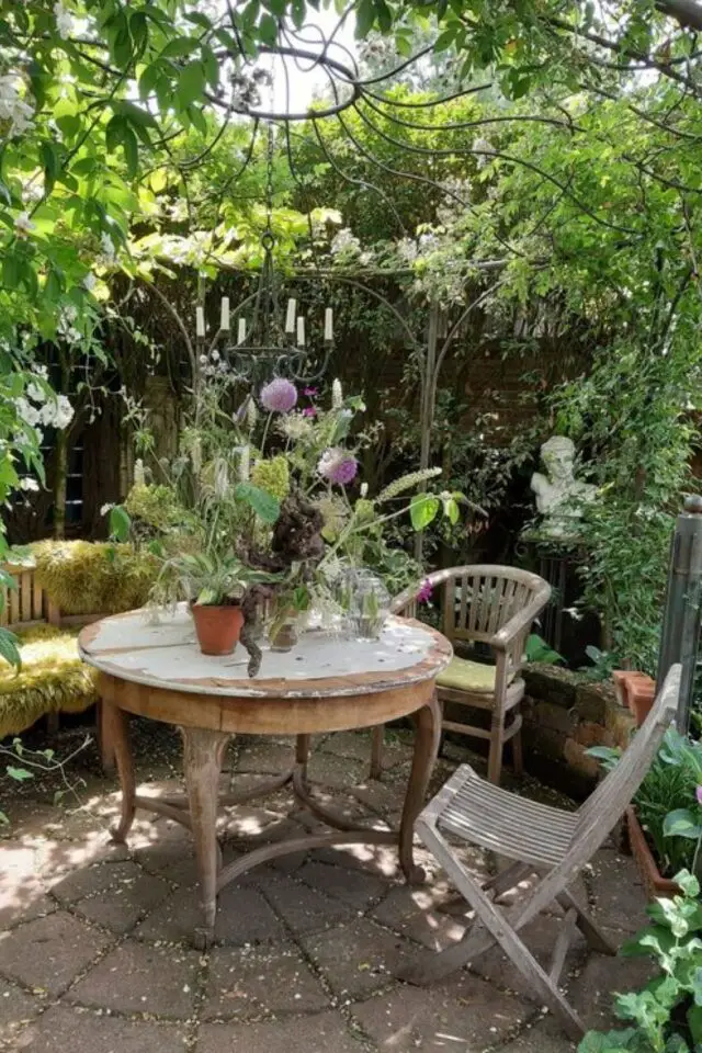 jardin rustique idée déco à copier table récup pergola en métal brocante plantes et fleurs statue en pierre