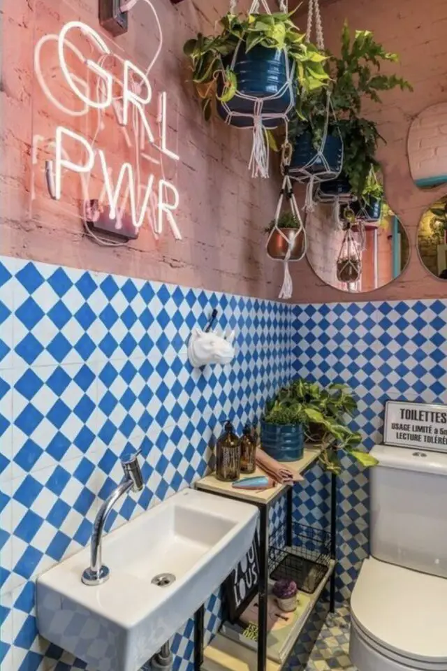 relooker les toilettes idees décoration murale originale et moderne néon girl power rose soubassement damier bleu électrique et blanc peinture plantes vertes et miroirs forme organique