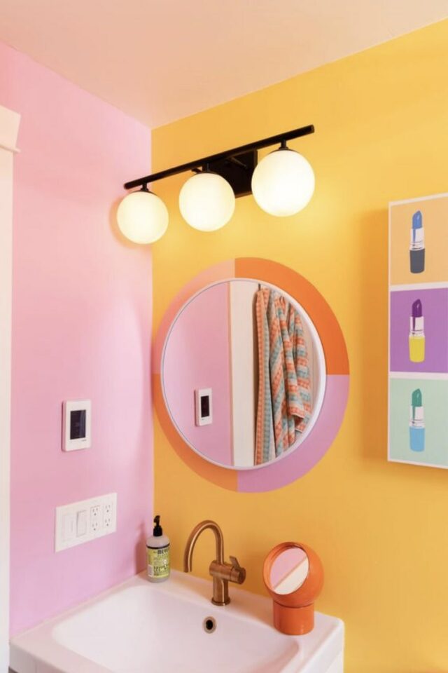 relooker les toilettes idees décor morderne couleur acidulées mise en valeur du miroir grâce à la peinture jaune rose orange 