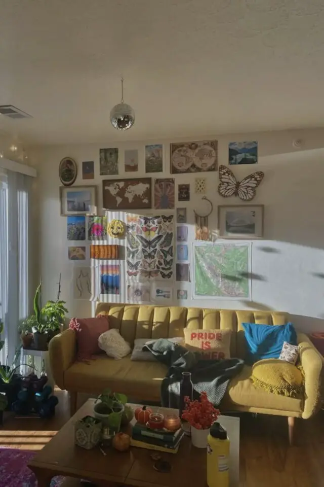 position canapé salon contre un mur avec espace de chaque côté plante verte dessus galerie de cadre ambiance jeune et dynamique 