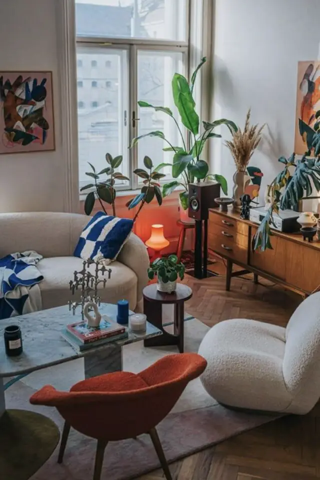 exemple place du canapé dans un salon pan de mur entre deux fenêtres face fauteuil design table basse en verre et meuble enfilade mid century modern 