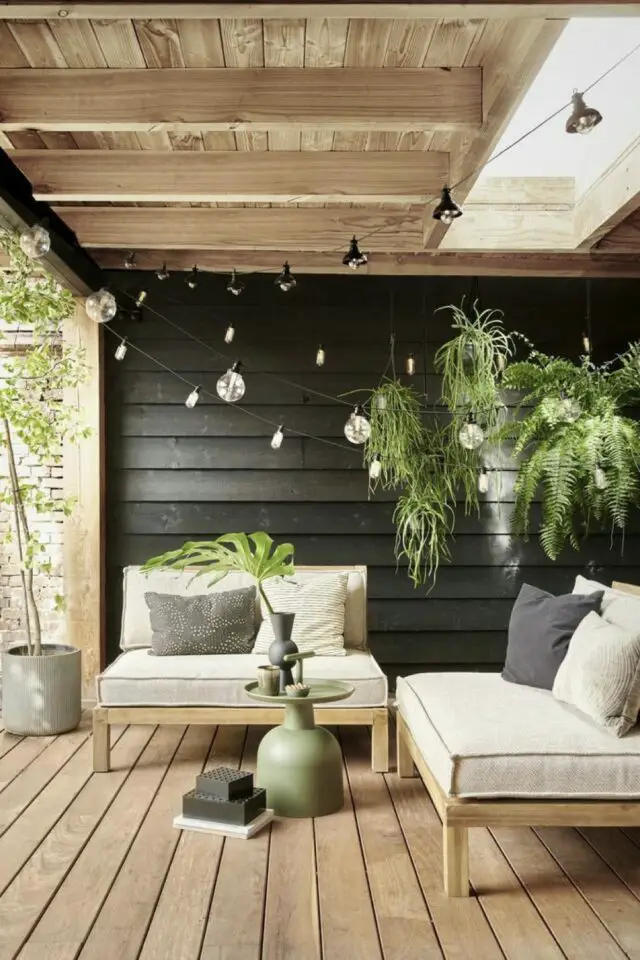 terrasse moderne en bois coin salon puit de lumière pergola lambris mural noir contraste éclairage guirlande lumineuse électrique 