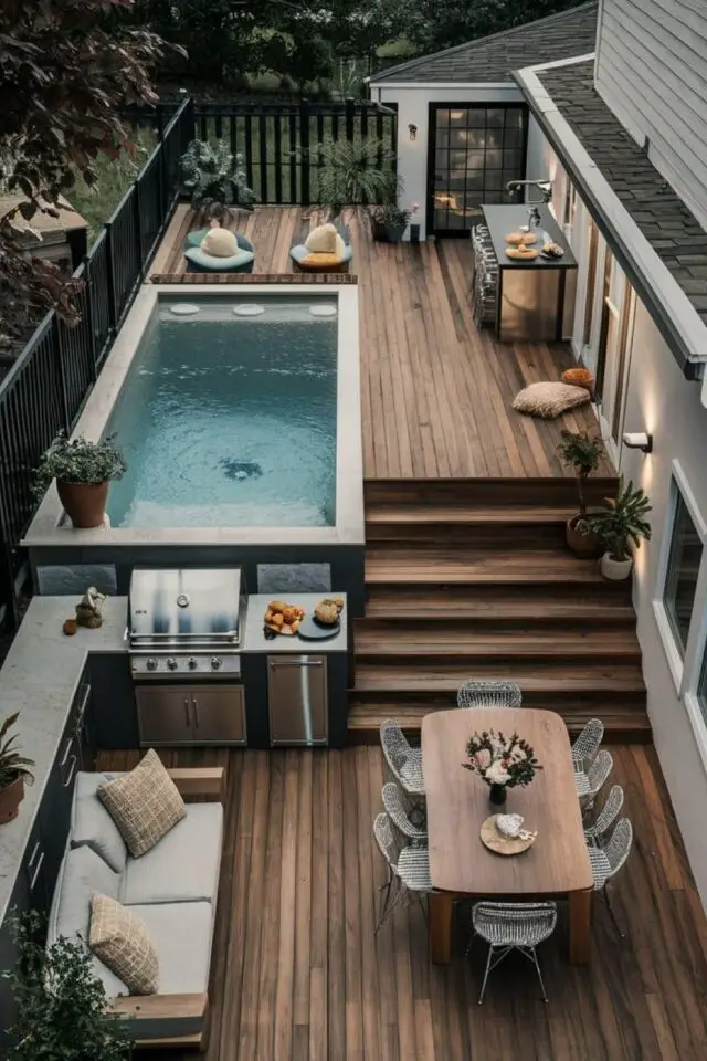 terrasse moderne en bois exemple plusieurs niveaux piscine cuisine extérieure table de repas et salon avec canapé lieu de vie clôture ajourée noir 