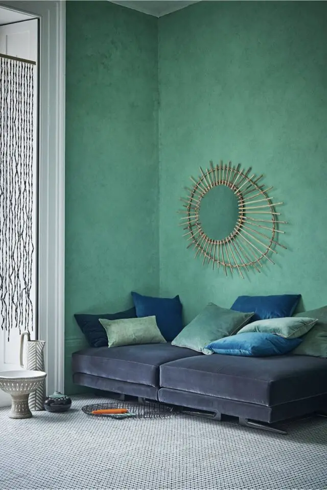 exemple déco bleu lagon salon moderne peinture texturée au mur canapé bleu marine en velours miroir soleil grand format chic et élégant 